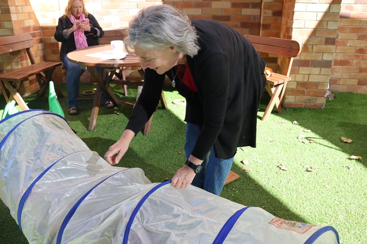 Sarah assists with rolling the tunnel for the children attending playgroup.