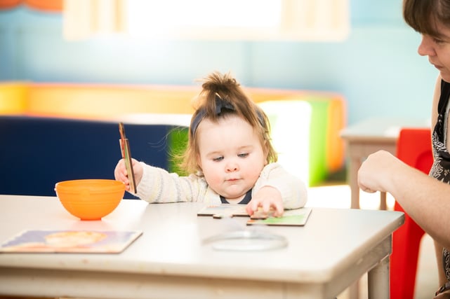 Child doing a puzzle with assistance from parent