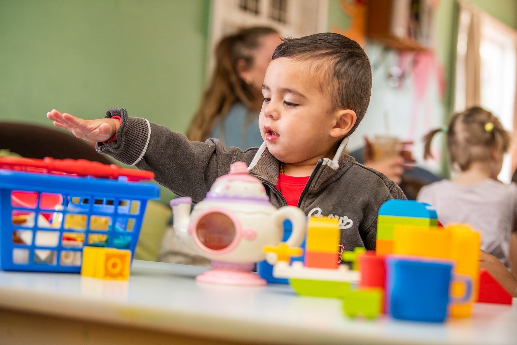 Child engaged in solitary play with blocks at playgroup