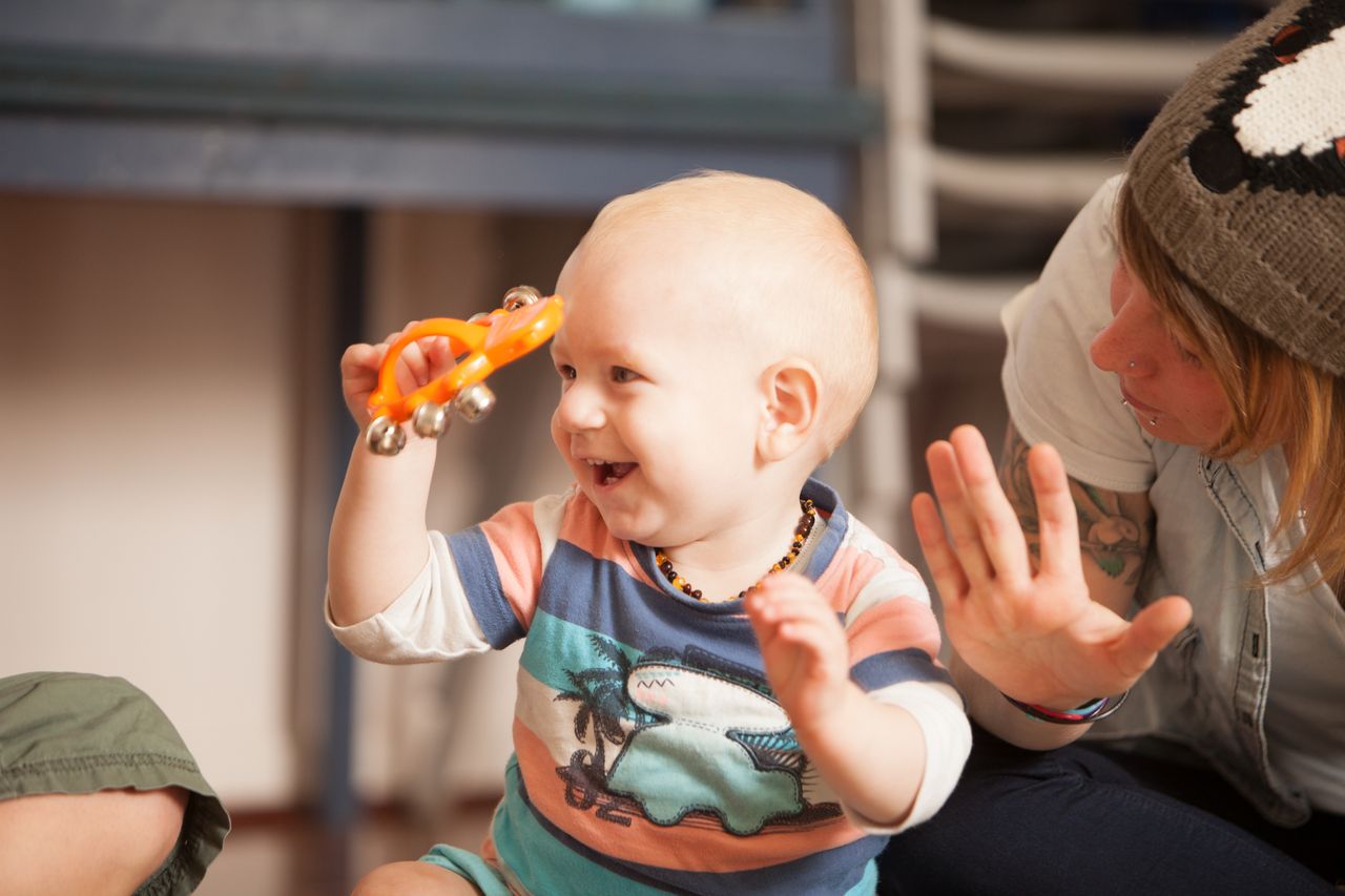 Child shaking bells and enjoying a playgroup music session