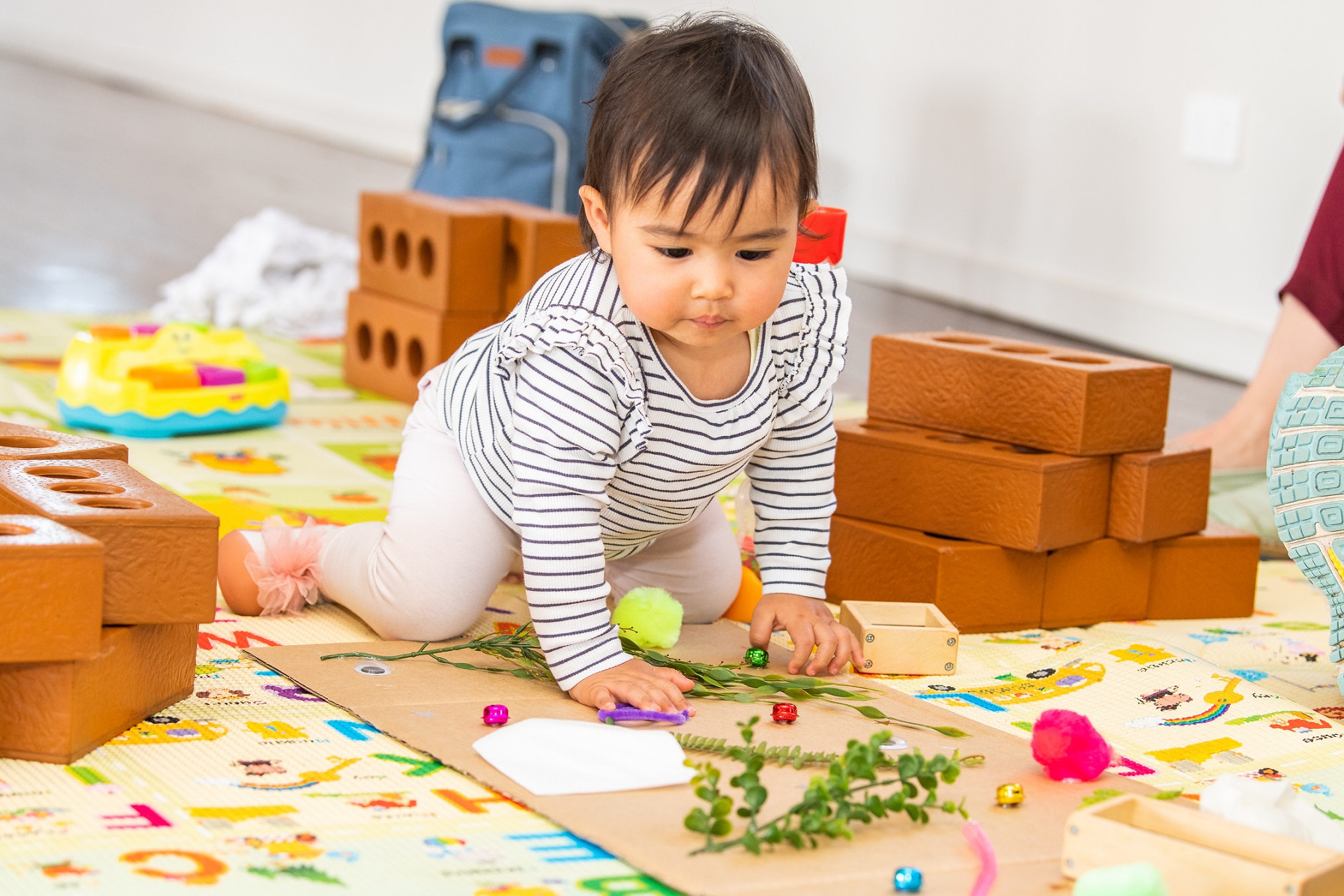 Baby exploring a sensory board during a playgroup session