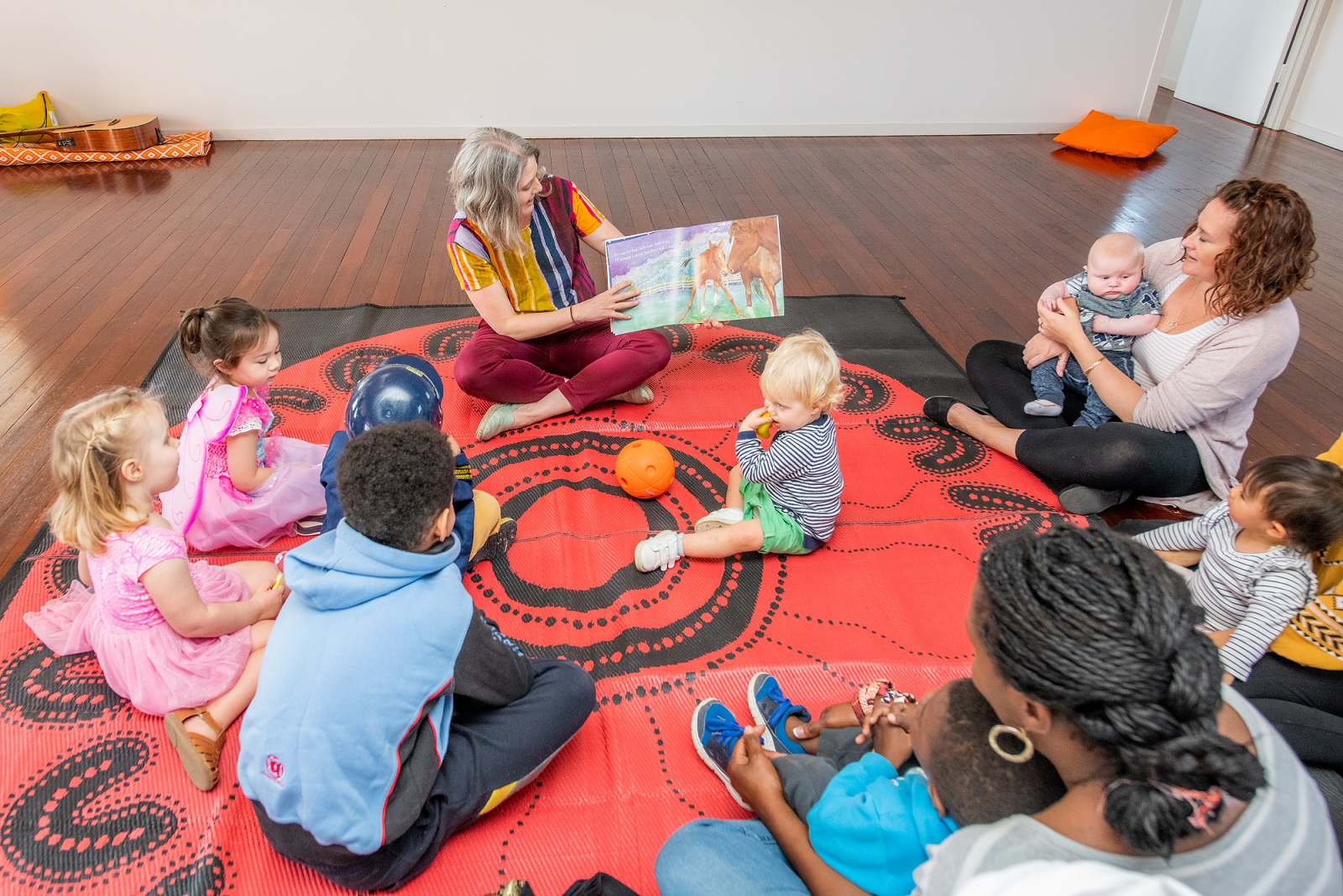 Volunteer reading a book to a group