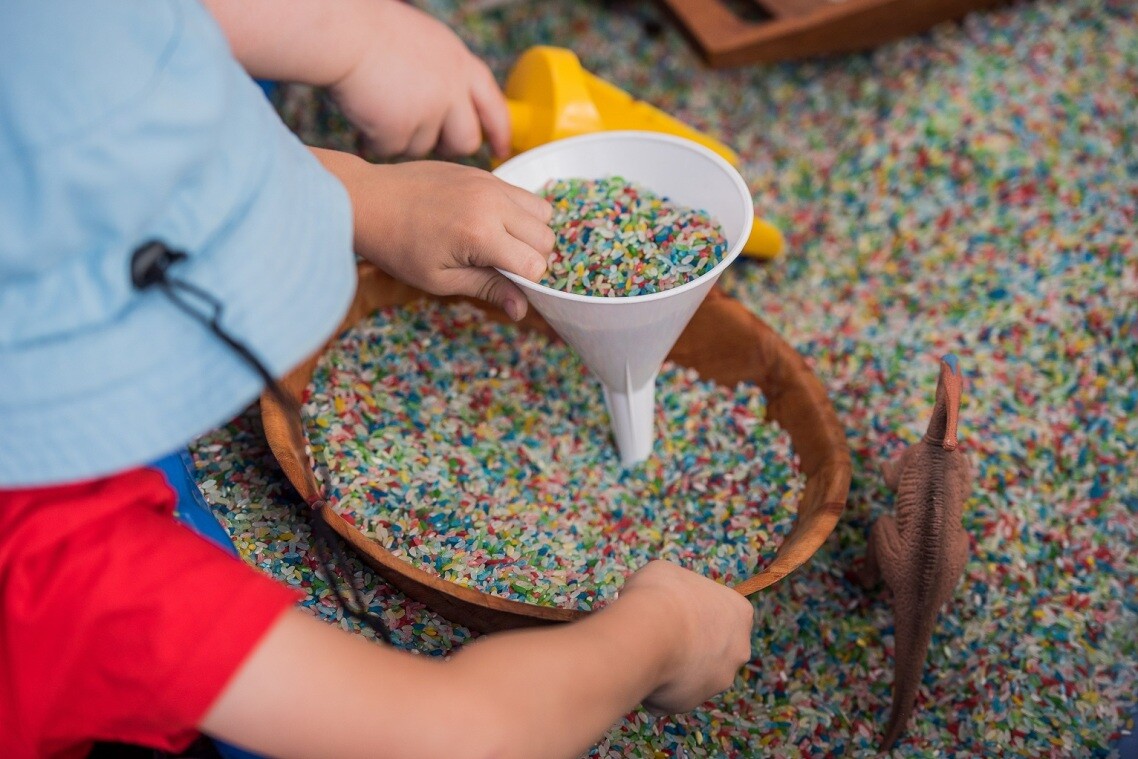 Image of Rainbow Rice sifting through a plastic funnel