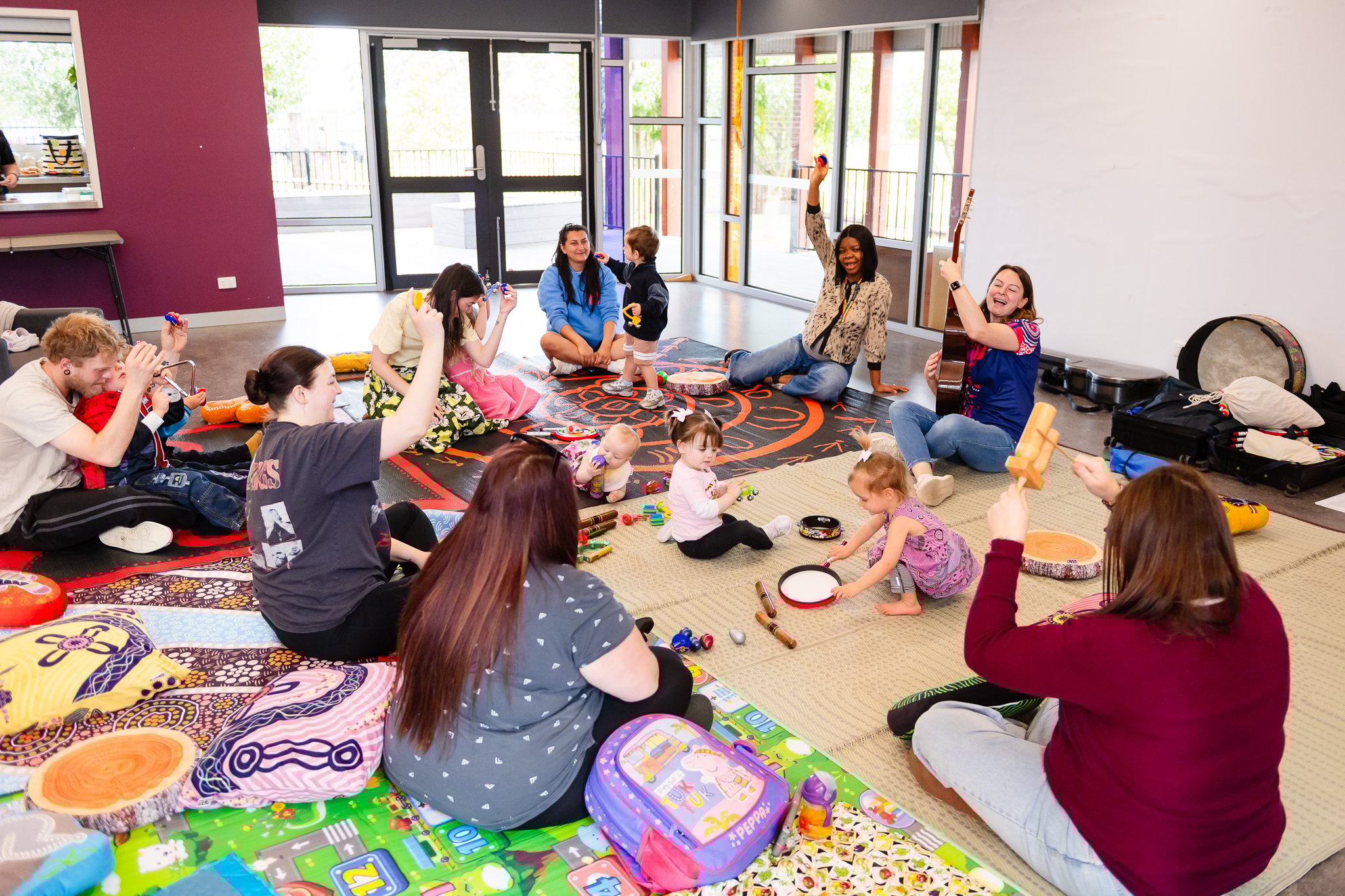 A group of parents and their children engage in group music therapy with a Sing&Grow registered music therapist.